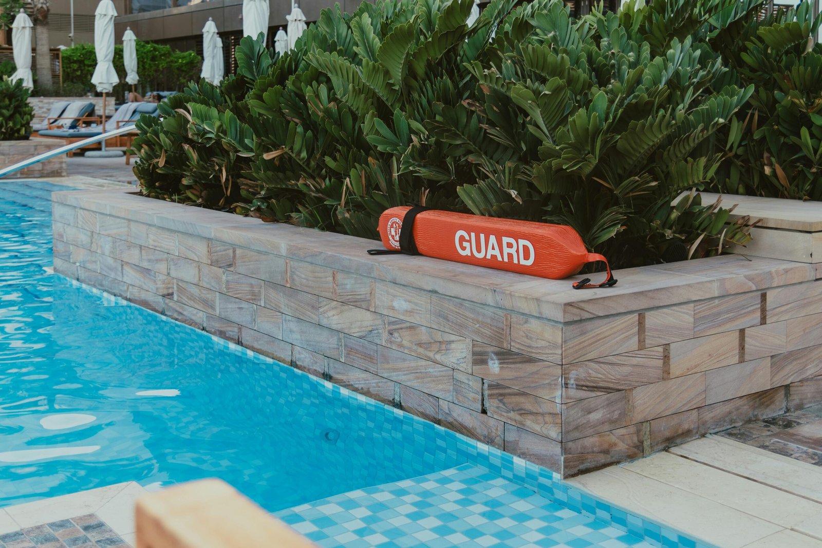Relaxing poolside area in a luxury Dubai resort with lifeguard equipment emphasizing safety and leisure.